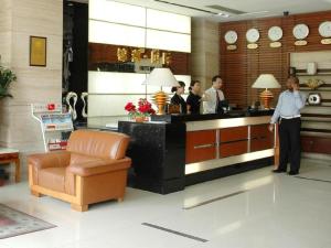a woman standing at a counter in a lobby at Jinzhou International Business Hotel in Guangzhou