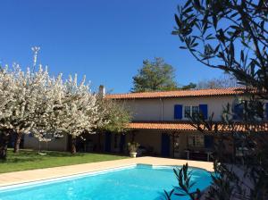 a villa with a swimming pool in front of a house at Le Relais Du Grand Logis in Civrieux