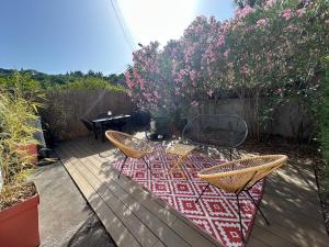 a patio with a table and chairs on a deck at Appartement spacieux in Jurançon