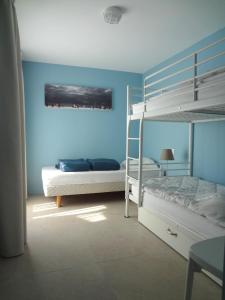 1 dormitorio con 2 literas y pared azul en La Conchee en Saint-Malo