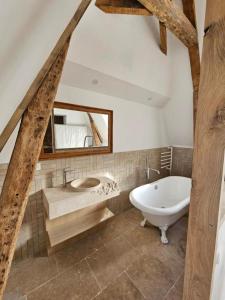 a bathroom with a tub and a sink and a mirror at La Villa du Clos Normand Les Petites Dalles - Maison d'hôtes in Saint-Martin-aux-Buneaux