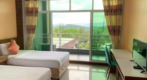 a room with two beds and a desk and a window at Breeze Hill Resort in Campson