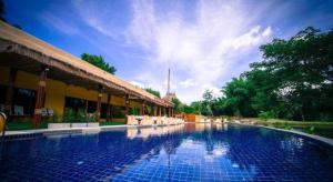 a swimming pool next to a building with a sky at Tammarene Villa in Ban Tha Khoei