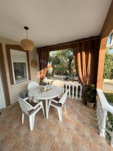 a dining room with a white table and chairs at Olivia apartment in Skala Sotiros
