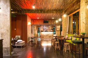 a restaurant with tables and chairs and a bar at Hadi Poetra Hotel in Kuta