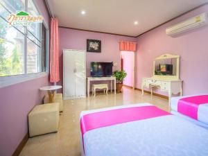 ein rosa Schlafzimmer mit zwei Betten und einem Fernseher in der Unterkunft Phutara Resort in Ban Bang Non Nai