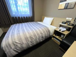 Postel nebo postele na pokoji v ubytování Hotel Route-Inn Kisarazu