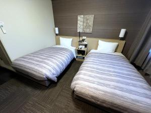 Postel nebo postele na pokoji v ubytování Hotel Route-Inn Kisarazu