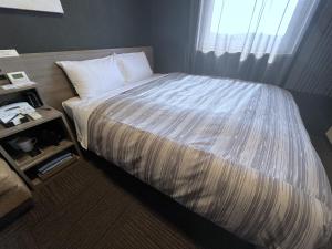 Postel nebo postele na pokoji v ubytování Hotel Route-Inn Kisarazu