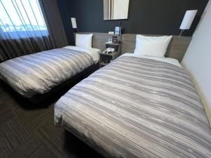 Postel nebo postele na pokoji v ubytování Hotel Route-Inn Kisarazu
