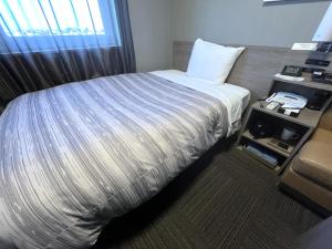 Postel nebo postele na pokoji v ubytování Hotel Route-Inn Kisarazu