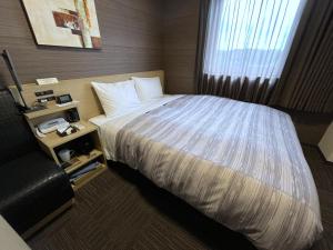Postel nebo postele na pokoji v ubytování Hotel Route-Inn Kisarazu