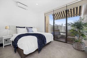 a bedroom with a bed and a large window at Mornington Beachfront Bliss - Pool, Spa & Rooftop Sunsets in Mornington +25 photos