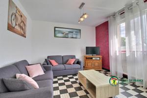 a living room with two couches and a tv at Ty lann in Pluvigner