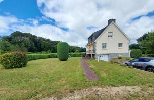 a large white house with a large grass yard at Ty lann in Pluvigner