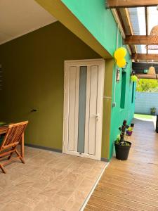 a door in a room with a green wall at La Maison Verte in Le Tampon