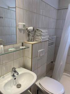łazienka z umywalką, toaletą i lustrem w obiekcie Nest Nocleg Poznań w Poznaniu +33 zdjęcia