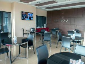 a restaurant with tables and chairs in a room at The Peak Boutique Hotel in Ban Hua Mi Na