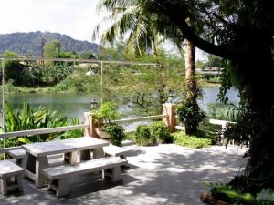 une table de pique-nique avec vue sur une rivière dans l'établissement Rommai Rimnaam Resort, à Ban Bang Rin (1)
