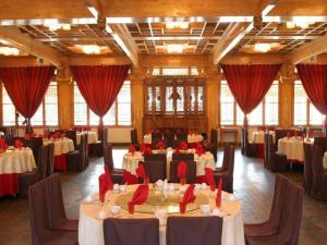 a large banquet hall with tables with red napkins at The Silk Road Dunhuang Hotel in Dunhuang