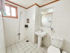 a white bathroom with a toilet and a sink at Seongsan Sunrise Pension in Seogwipo +18 photos