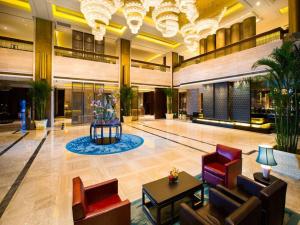 a lobby of a hotel with chairs and tables at New Century Grand Hotel Hangzhou Zheshang in Yuhang