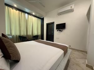 a hotel room with a bed and a tv at Sariska Celebration Hotel & Resort in Alwar
