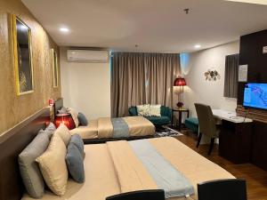 a hotel room with two beds and a television at FirIzzkey Studio in Kota Bharu