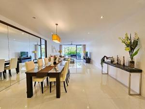 a dining room and living room with a table and chairs at 2 Bedrooms Apartment pool access in Ban Lum Fuang