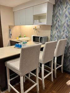 a kitchen with a table with chairs and a microwave at FirIzzkey Studio in Kota Bharu