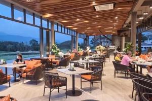 a restaurant with tables and chairs and people sitting at tables at Royal Hills Golf Resort and Spa in Ban Som Phung Haeng (1)