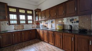 a kitchen with wooden cabinets and a counter top at Delight Villa in Tangalle