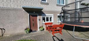 a red table and bench in front of a building at Apartamentai AGNIJA in Kretinga