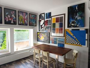 a dining room with a wooden table and some paintings at Apartmán Doupě in Humpolec +35 photos