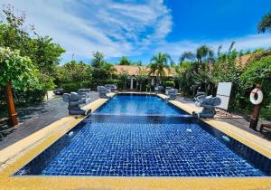 a swimming pool in a resort with chairs around it at Baan Kiangnam Pattaya Resort in Ban Pong +104 photos