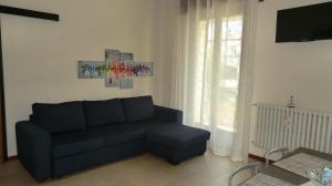 ein Wohnzimmer mit einem blauen Sofa und einem Fenster in der Unterkunft Salvi in Peschiera del Garda