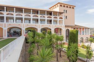 a building with palm trees in front of it at Residence Le Hameau Cap Esterel - maeva Home in Agay - Saint Raphael