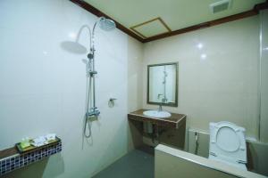 a bathroom with a sink and a toilet and a mirror at AmornSukhothai Hotel in Sukhothai +35 photos