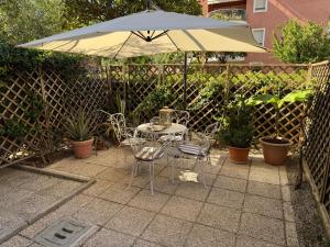 a table and chairs under an umbrella on a patio at Rimini centro - Residenza Romy con giardino - 5 posti letto in Rimini