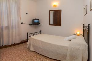 1 dormitorio con 1 cama y TV en la pared en Casa a San Giovanni Paolo, en Venecia