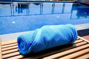 a blue towel sitting next to a swimming pool at Elegancy Sansabai Hotel in Patong Beach
