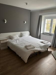 a bedroom with a white bed with two towels on it at Petite chatelaine in Herbeumont
