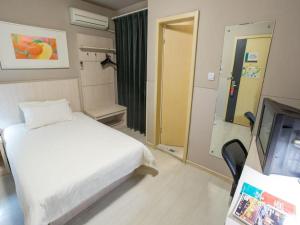 a hotel room with a bed and a television at Jinjiang Inn Shanghai Baoshan Shengqiao in Luodian