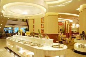 eine große Lobby mit Essbereich und Buffet in der Unterkunft New Century Hotel Ninghai in Shang-ts'un