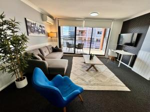 a living room with a couch and a blue chair at Modern 2-Bedroom Apartment 7mins to Paramatta Train Station in Sydney