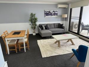 a living room with a couch and a table at Modern 2-Bedroom Apartment 7mins to Paramatta Train Station in Sydney