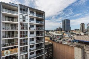 a tall white building with a city in the background at Modern 2-Bedroom Apartment 7mins to Paramatta Train Station in Sydney