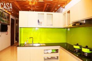 a green and white kitchen with a sink and a counter at Dalat CASA in Ấp Kim Thạch