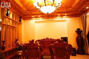 a dining room with a table and chairs and a chandelier at Dalat CASA in Ấp Kim Thạch