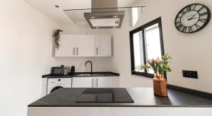 a kitchen with a sink and a clock on the wall at Mi Casa Es Su Casa Nº4 in Albufeira